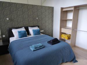 Un dormitorio con una cama con almohadas azules. en Au Simply, en Francorchamps