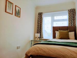 a bedroom with a large bed and a window at 3BR House with garden near Bicester Village in Bicester