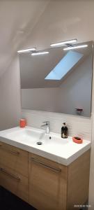 een badkamer met een wastafel en een spiegel bij Gîte VILLA ESPERANZA (2-6 personnes) in Valençay