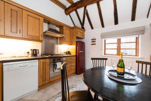 a kitchen with a table with a bottle of wine on it at Hideaway Cottage Bewdley with parking near the River Severn in Bewdley