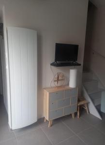 a tv sitting on top of a dresser in a room at À moins de 500m de la plage, 2 adultes - 3 enfants in LʼÉpine