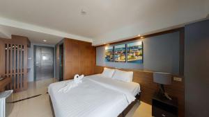 a bedroom with a large white bed in a room at PP@Hotel Rangsit in Pathum Thani