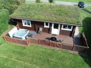 an overhead view of a log cabin with a deck and a hot tub at Partridge Lodge in Selby