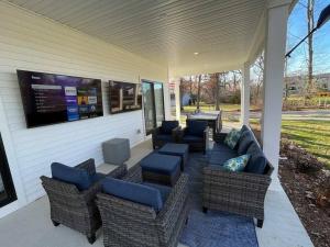 a screened porch with couches and chairs and a tv at Luxury Estate with Stadium TDJ Views Sleeps 20 in South Bend