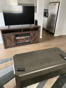 a living room with a tv and a coffee table at Bi-Level Suite in Saskatoon in Saskatoon