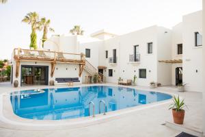 een zwembad voor een wit gebouw bij Bitez Corner Boutique Hotel in Bitez