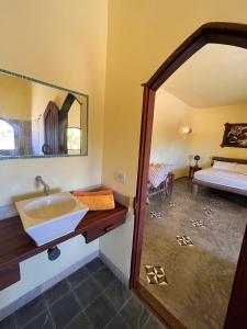 ein Bad mit einem Waschbecken und einem Spiegel in der Unterkunft Pousada Akronos in Canoa Quebrada