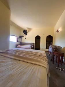 1 dormitorio con 2 camas, mesa y ventana en Pousada Akronos en Canoa Quebrada