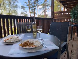 a table with a bottle of wine and a plate of food at Apartmán Verča Riviera Lipno 510 in Lipno nad Vltavou