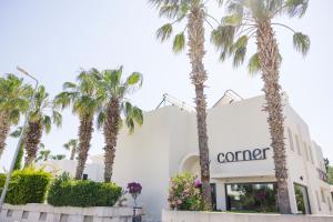 a building with palm trees in front of it at Bitez Corner Boutique Hotel in Bitez