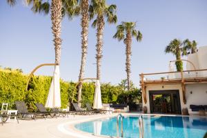 a pool at a hotel with palm trees at Bitez Corner Boutique Hotel in Bitez