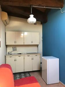 uma cozinha com armários brancos e uma parede azul em da nonna Emi em Módena