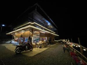 a motorcycle parked in front of a building at night at Bao Lac Homestay Hostel & Coffee in Bảo Lạc