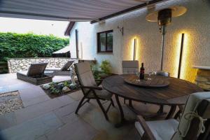 un patio con mesa de madera y sillas en Woodhead view en Kirkintilloch