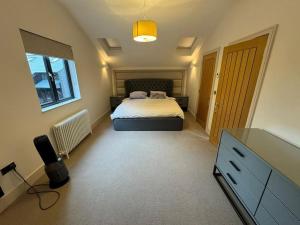 a bedroom with a bed and a dresser in it at NORTHBRIDGE in Tonbridge
