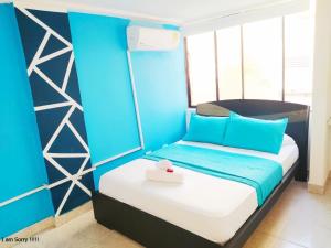 Un pequeño dormitorio con una cama azul y blanca en APT en EDF Frente a la playa y cercano centro Histórico 1-2, en Cartagena de Indias