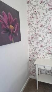 a room with a table and a flower patterned wall at The Abbotsford in Callander