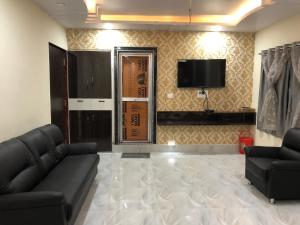 a living room with a couch and a tv at Hotel The Heaven in Muzaffarpur