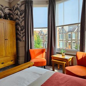 sypialnia z łóżkiem, 2 krzesłami i oknem w obiekcie The Corner House w mieście Lowestoft