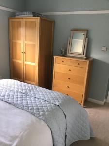 - une chambre avec un lit, une commode et un miroir dans l'établissement A place to stay in Stoke Gifford, à Bristol