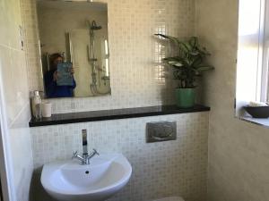 a woman taking a picture of a bathroom with a sink at A place to stay in Stoke Gifford in Bristol