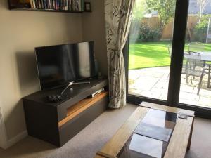 sala de estar con TV de pantalla plana y ventana en A place to stay in Stoke Gifford, en Bristol
