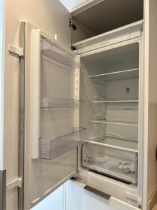 an empty refrigerator with its door open at CASTILLA LUXURY B Apartments in Madrid