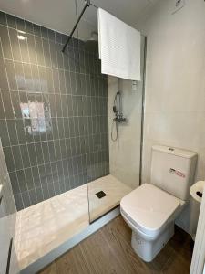 a bathroom with a toilet and a glass shower at CASTILLA LUXURY B Apartments in Madrid