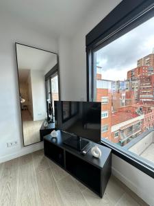 a living room with a large window and a television at CASTILLA LUXURY B Apartments in Madrid