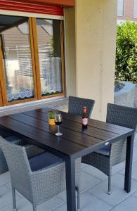 uma mesa de madeira com 2 cadeiras e uma garrafa de vinho em Ruheort em Beinwil