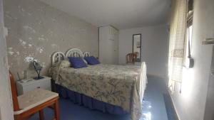 Un dormitorio con una cama con almohadas azules. en Finca Las Dunas con dos Chalets con jacuzzis en primera linea de playa uno de 4 dormitorios y otro de 2 dormitorios, en Rota