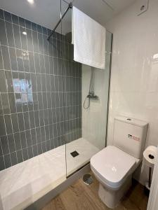 a bathroom with a white toilet and a shower at Castilla Luxury 2B Apartment in Madrid