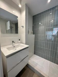 a white bathroom with a sink and a shower at Castilla Luxury 2B Apartment in Madrid