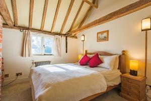 a bedroom with a large bed with red pillows at The Oast by Bloom Stays in Newenden
