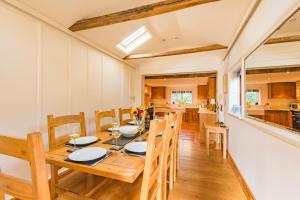 a dining room with a table and chairs and a kitchen at The Oast by Bloom Stays in Newenden