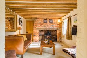 a living room with a brick fireplace and a couch at The Oast by Bloom Stays in Newenden