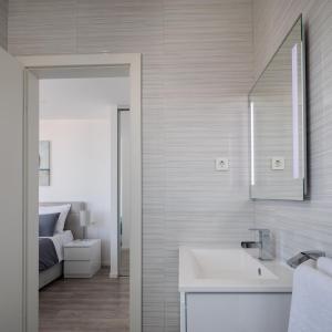 a white bathroom with a sink and a bed at House Villa Z&Z in Seget Vranjica