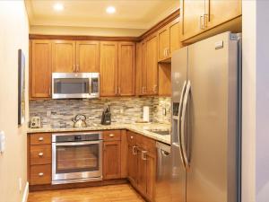 eine Küche mit Holzschränken und Geräten aus Edelstahl in der Unterkunft River Club 105 by Alpine Lodging Telluride in Telluride
