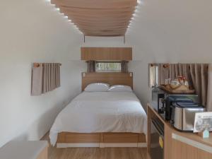 sypialnia z dużym łóżkiem z drewnianym zagłówkiem w obiekcie Sky The Campers w mieście Chiang Dao