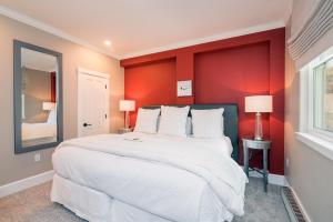 ein Schlafzimmer mit einem großen weißen Bett mit roten Wänden in der Unterkunft River Club 105 by Alpine Lodging Telluride in Telluride