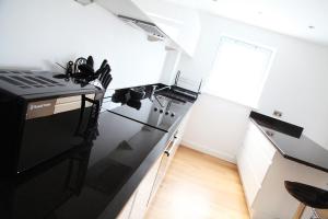a kitchen with a black refrigerator and a counter at Azure 7 Apartment in Newquay