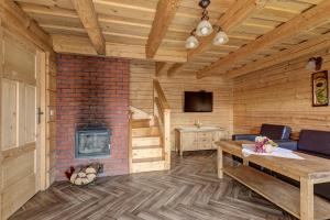 sala de estar con chimenea y mesa en Kotelnica Resort en Międzybrodzie Bialskie