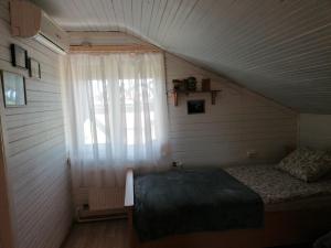 a small bedroom with a bed and a window at GARDEN CHALET in Daugavpils