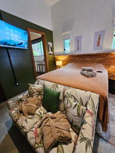 a bedroom with a large bed and a couch at Pousada Quinta das Nascentes in Petrópolis
