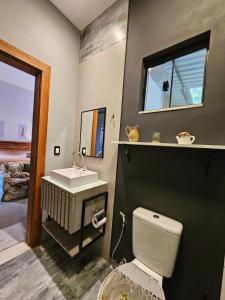 uma casa de banho com um WC branco e um lavatório. em Pousada Quinta das Nascentes em Petrópolis