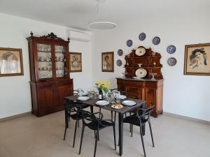 een eetkamer met een tafel met stoelen en een klok bij Casa Zolì - Luxury House - 210mq in Palermo