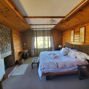 a bedroom with a large bed in a wooden room at Walkers Peak Cottage in Underberg