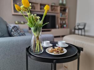 een tafel met twee borden eten en een vaas met bloemen bij Casa Zolì - Luxury House - 210mq in Palermo