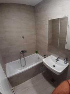 ein Badezimmer mit einer weißen Badewanne und einem Waschbecken in der Unterkunft Apartman City BL in Banja Luka