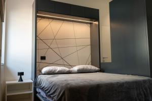 a bedroom with a bed with a large headboard at Residenza Diaz in Domodossola